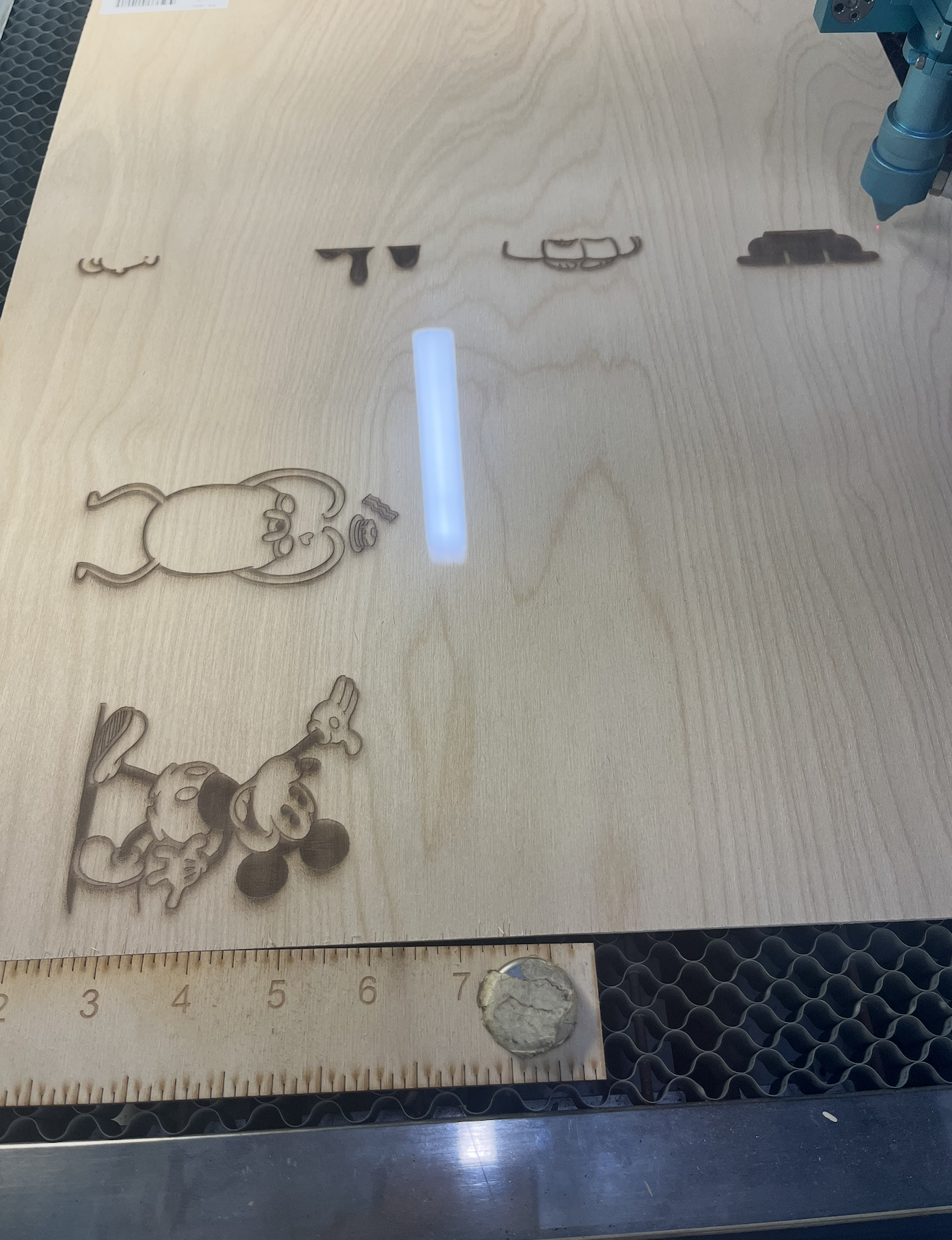 An image taken while working in a group to complete the laser cutting activity as the laser appears on the wood.
